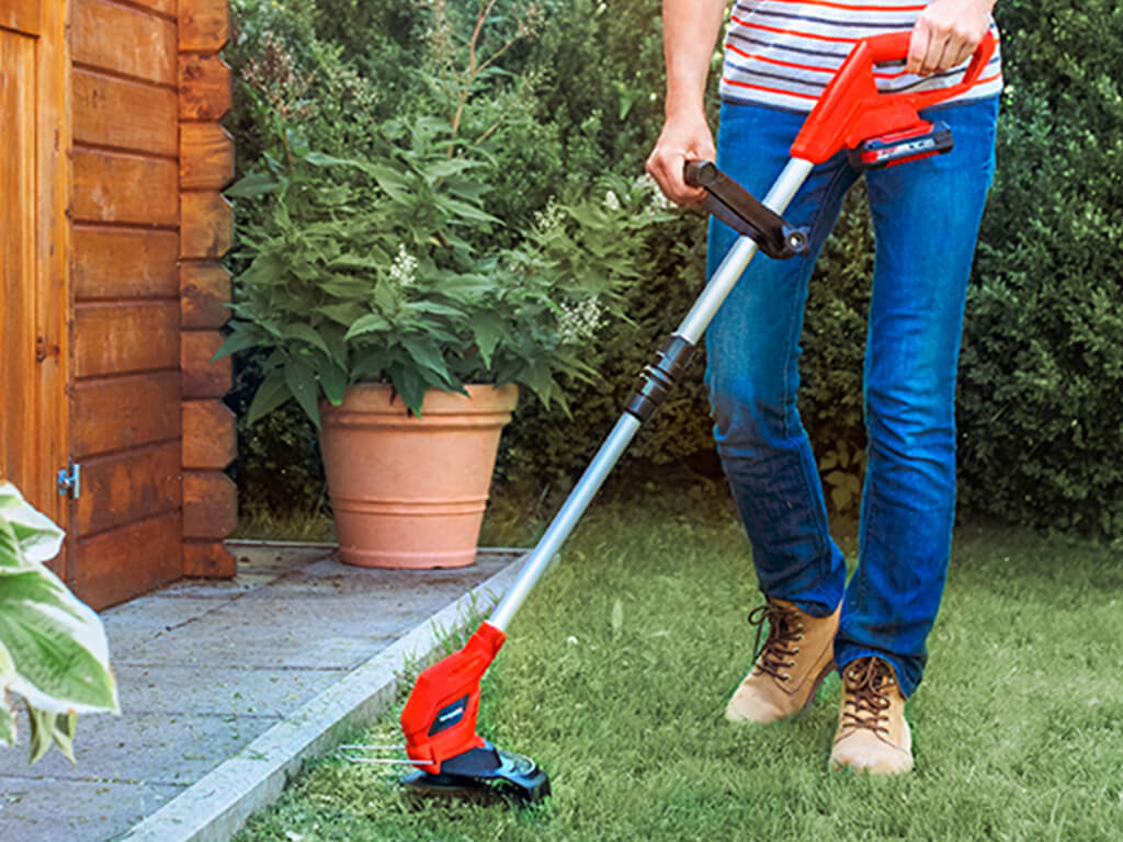 A woman working with a Einhell lawntrimmer 