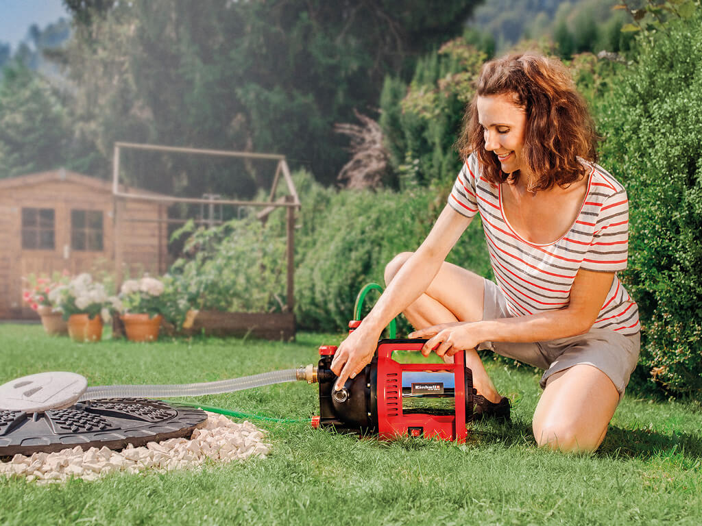 A woman is working with her cordless garden pump
