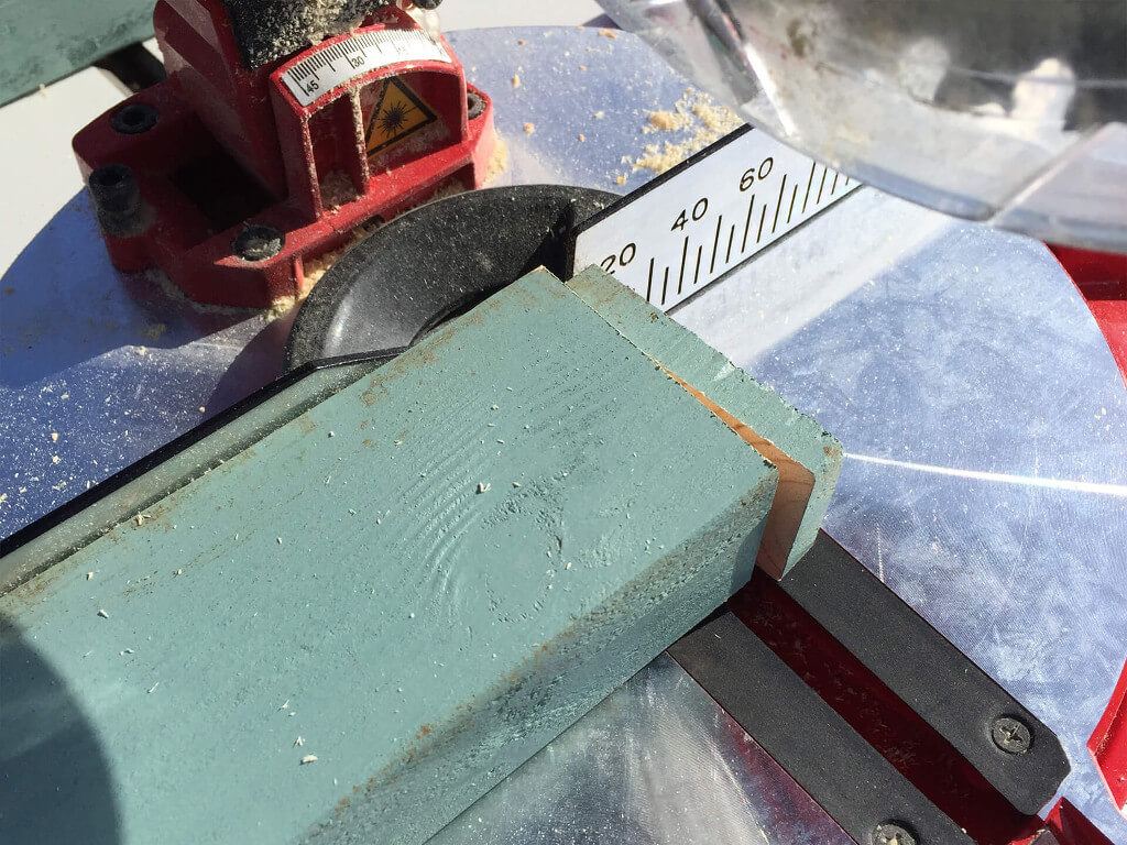 Wood piece getting cut by a mitre saw.