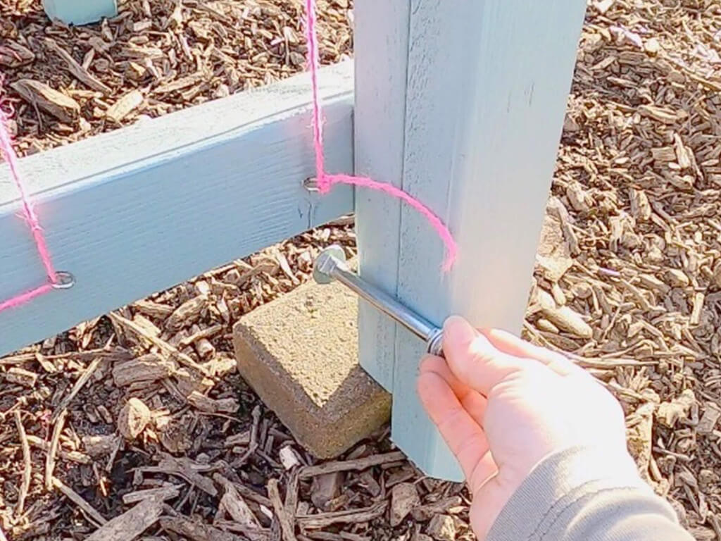 Pink ropes that are attached on a hook of the wood piece.