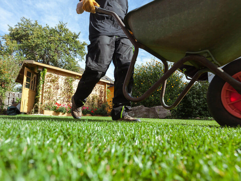 A man pushing a wheelbarrow.