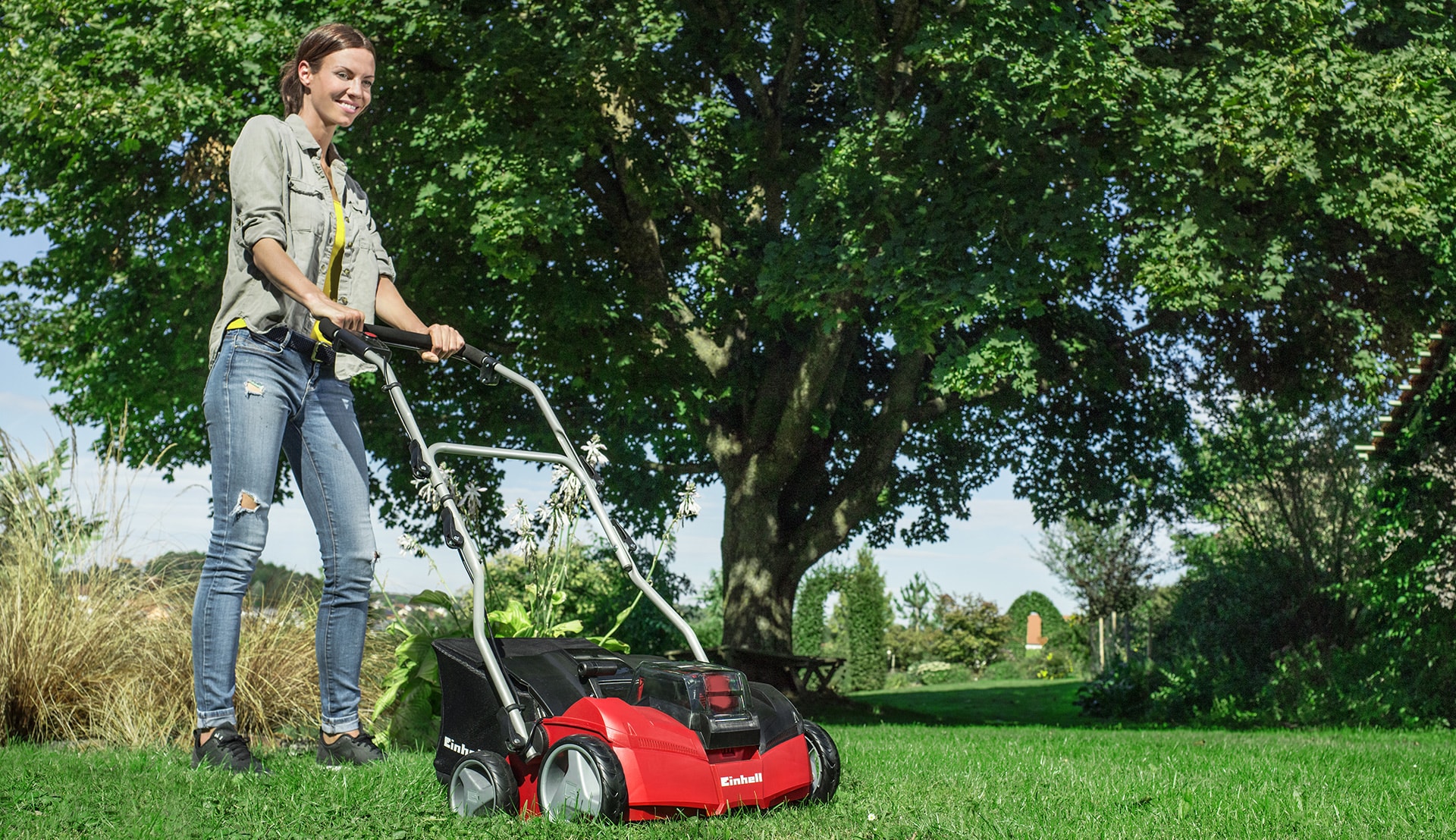 A woman scarifying the lawn.