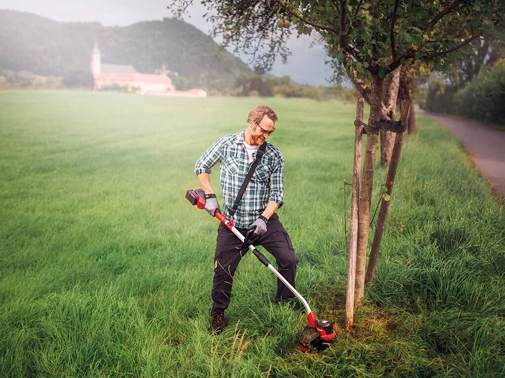 A man trimming the lawn. 