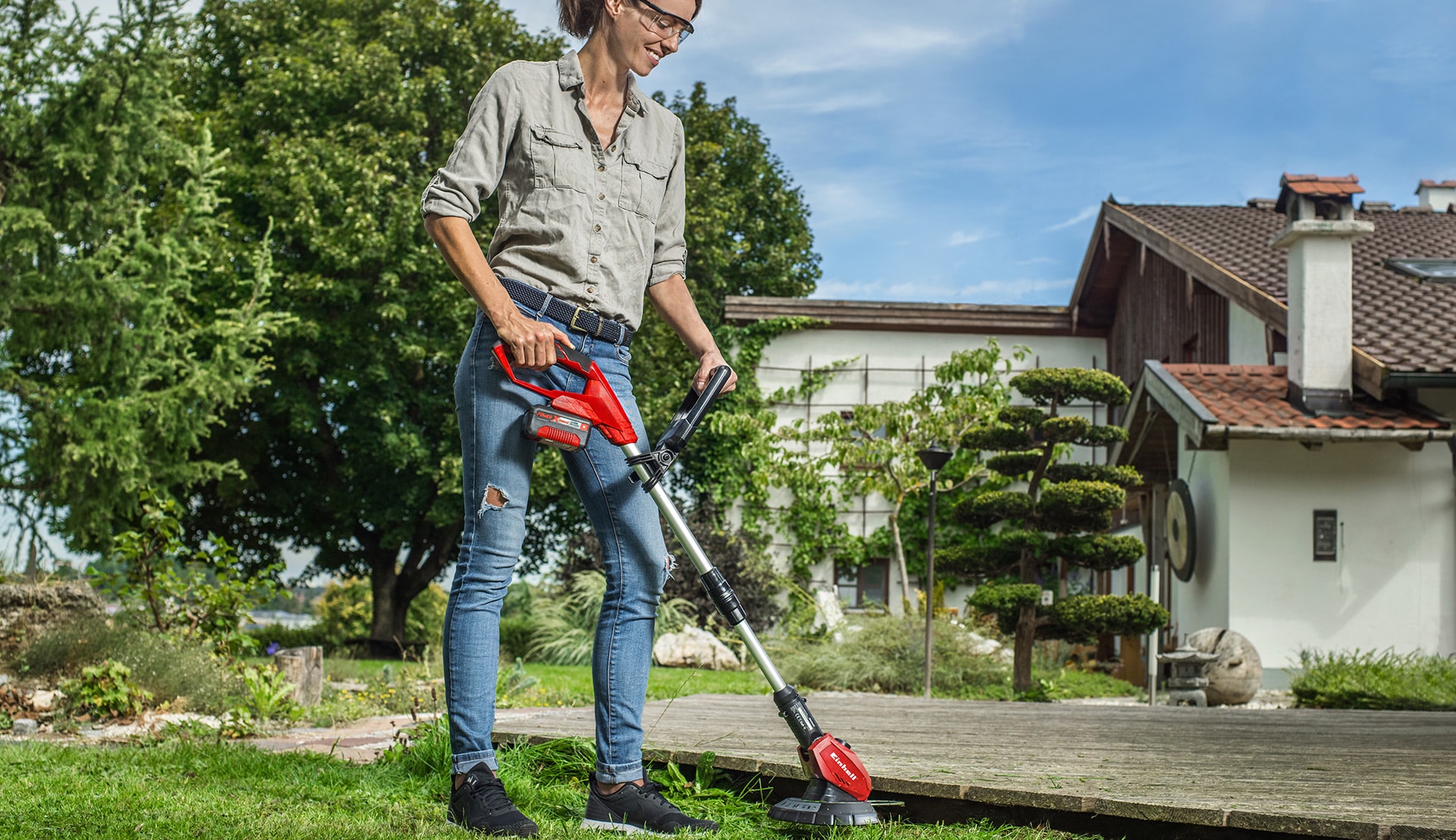 A woman trimming the lawn.