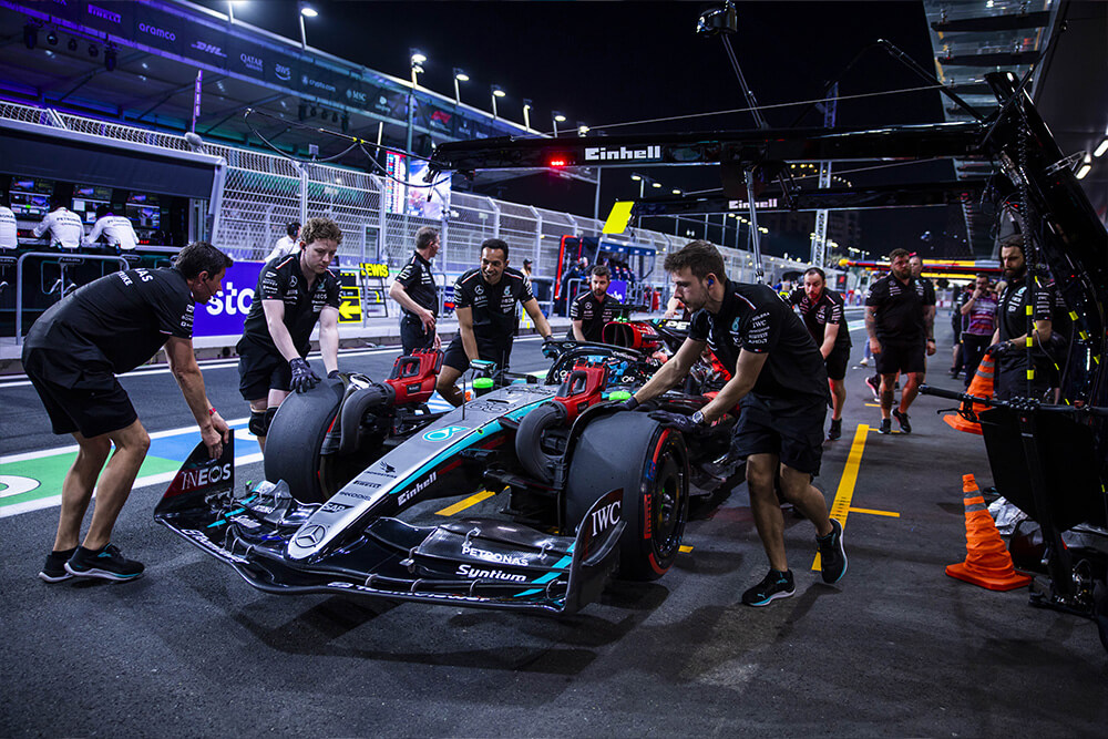 Formula 1 Mercedes race car being surrounded by mechanics and the team.