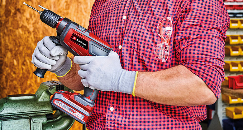 A man holding the cordless driller. 