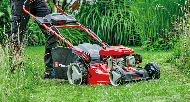 A petrol lawnmower with a robust housing made of powder-coated sheet steel.